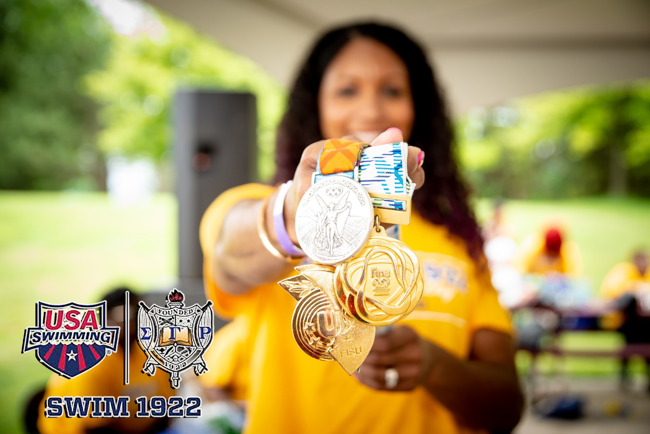 Maritza McClendon holding a handul of medals